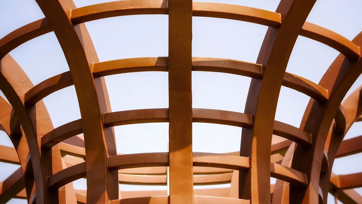 Pergola under byggnation med stolpar och takribbor